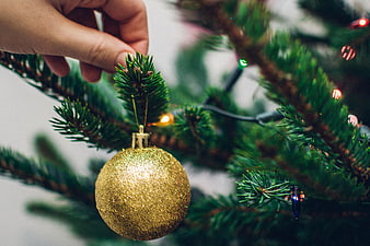 Hand Hanging Gold Glitter Ornament on Christmas Tree