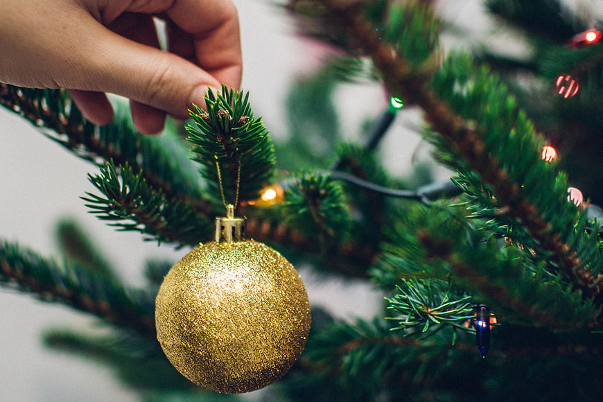 Hand Hanging Gold Glitter Ornament on Christmas Tree