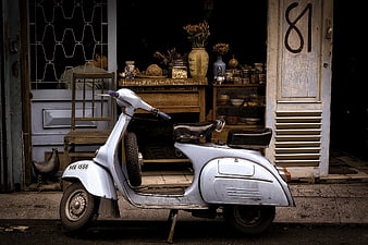 Vintage Silver Scooter Parked Outside Rustic Shop