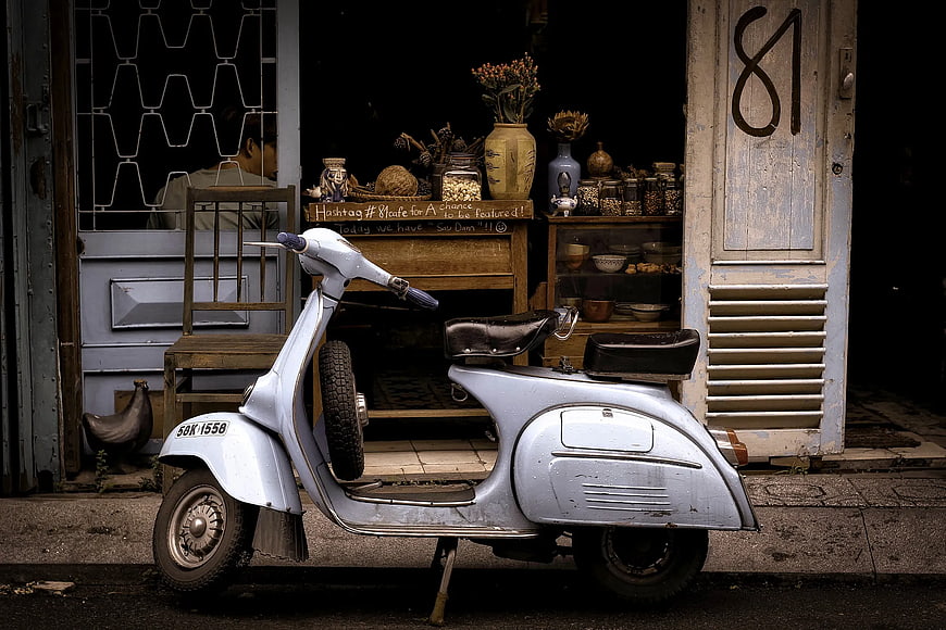 Vintage Silver Scooter Parked Outside Rustic Shop
