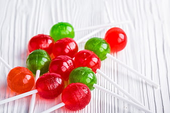 Colorful Red and Green Lollipops on White Wood