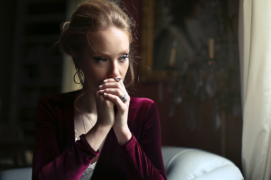 Pensive Woman in Burgundy Velvet Jacket Looking Away