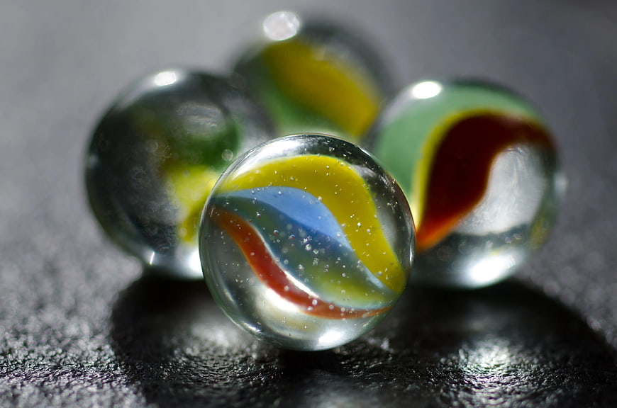 Close-up of colorful glass marbles on dark surface