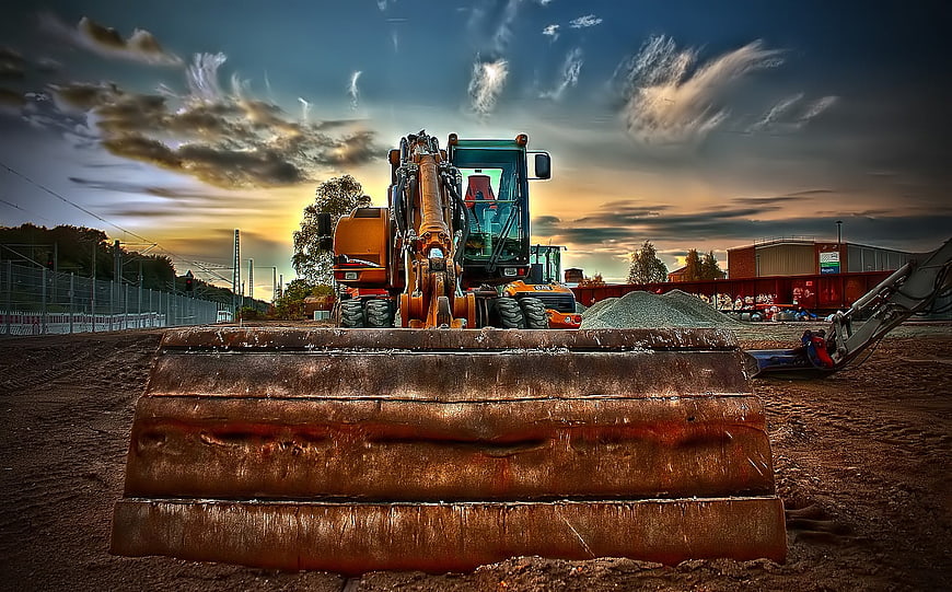 Rusty Excavator Bucket on Construction Site at Sunset