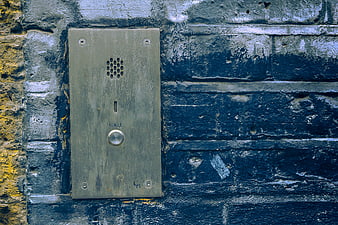 Vintage intercom on weathered blue brick wall