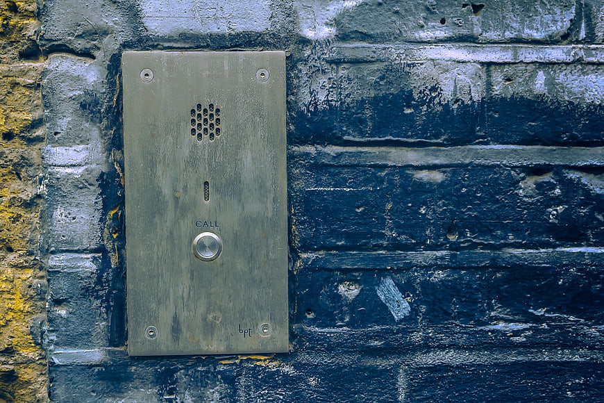Vintage intercom on weathered blue brick wall