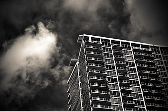 Dramatic Black and White Skyscraper Against Stormy Clouds