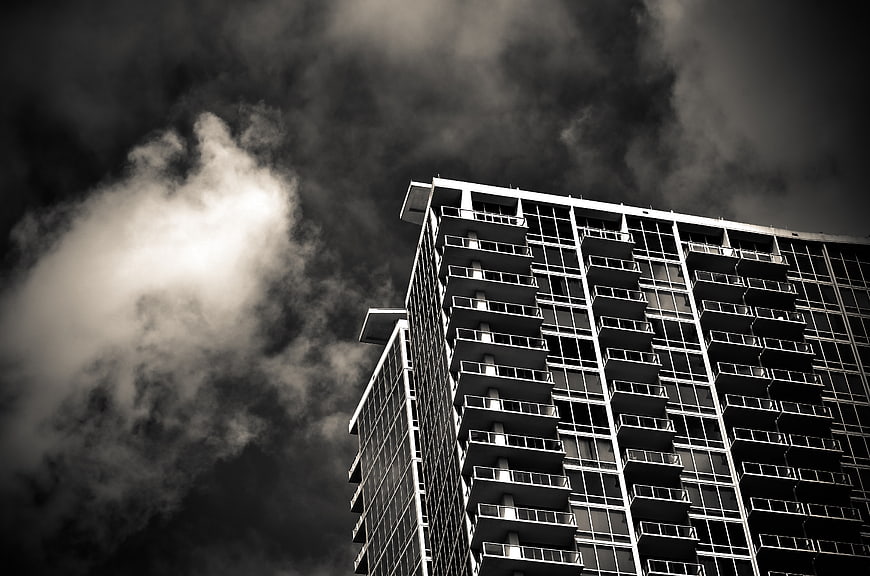 Dramatic Black and White Skyscraper Against Stormy Clouds