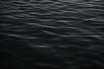 Dark rippling water surface with subtle golden reflections