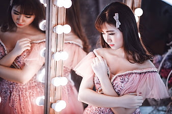 Young Asian Woman in Pink Dress Posing in Front of Vanity Mirror