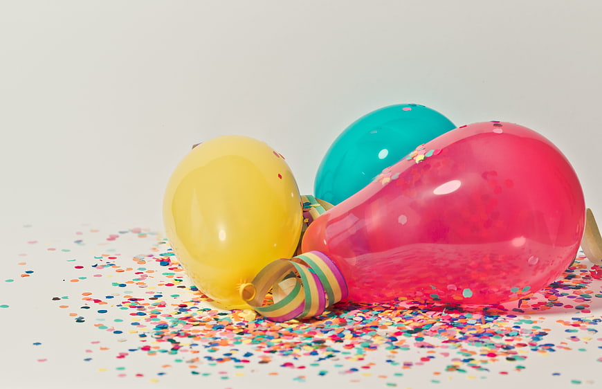 Colorful balloons and confetti on white background