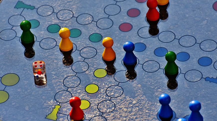 Colorful Ludo Board Game Pieces and Dice on Glass