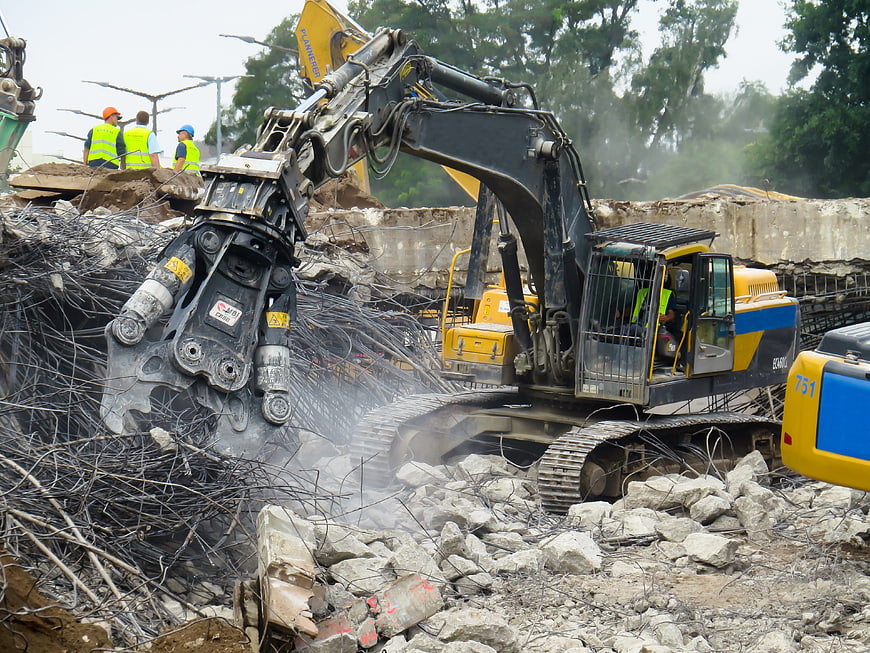 Heavy Excavator Demolishing Concrete Structure with Steel Rebar