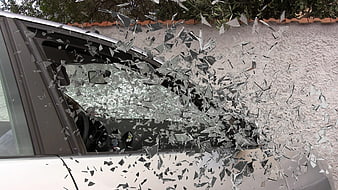 Shattered car window glass flying in mid-air