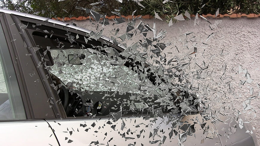 Shattered car window glass flying in mid-air