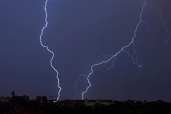Dramatic Lightning Bolts Striking Over City Skyline at Night