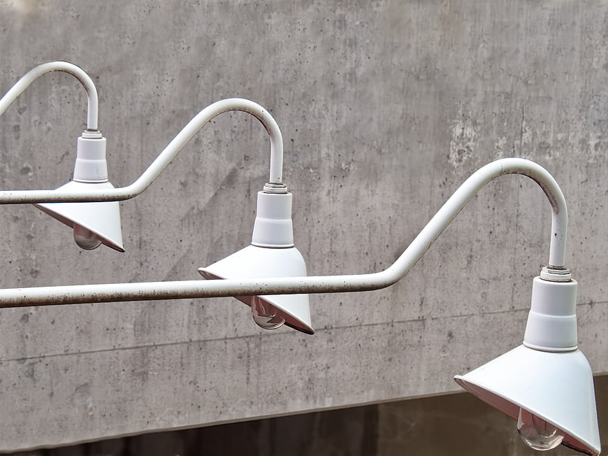 White industrial pendant lights against concrete wall