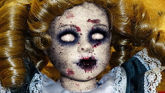 Close-up of a creepy vintage doll with bloody face and hollow eyes