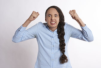 Angry woman screaming with clenched fists on white background