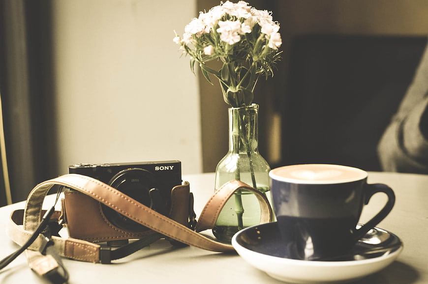 Vintage Camera, Coffee, and Flowers on Table
