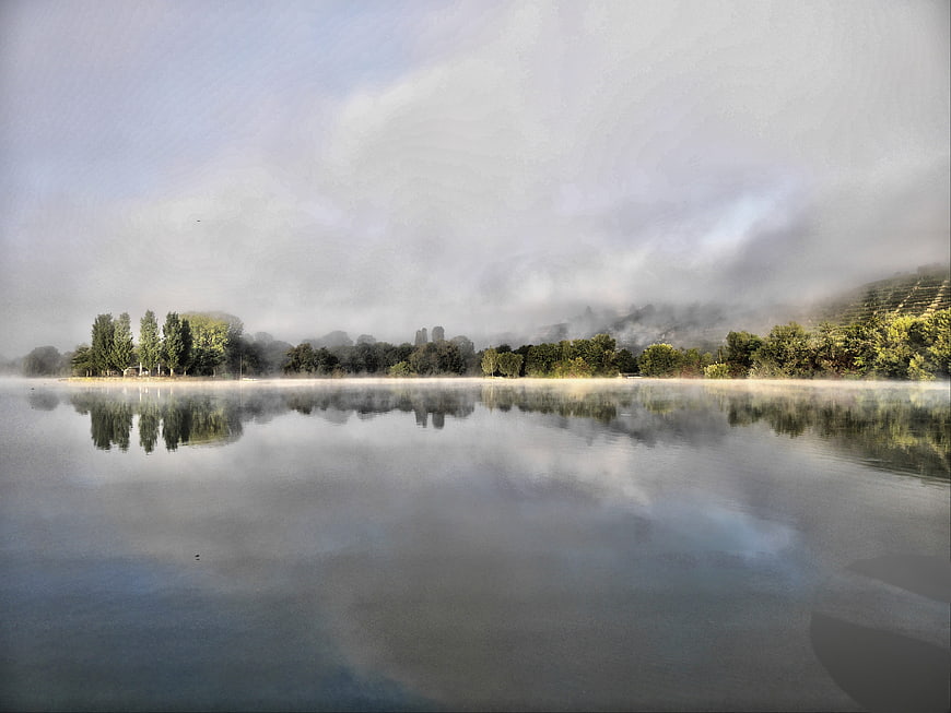 Serene Misty Lake Landscape with Tree Reflections