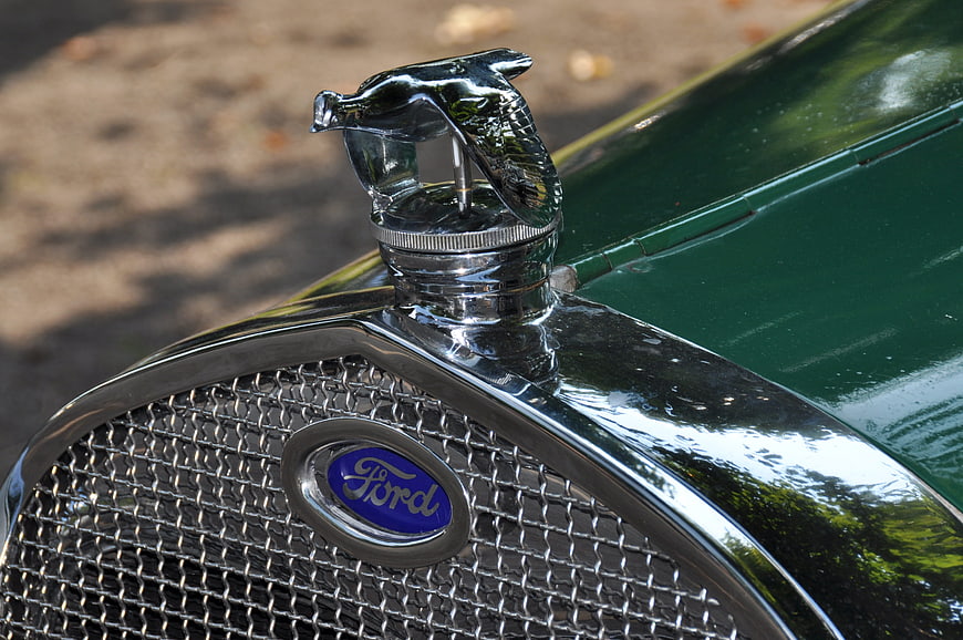 Close-up of vintage Ford car hood ornament and grille