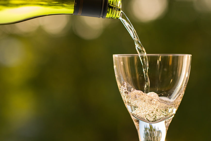 Pouring White Wine into Glass Outdoors