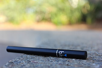 Black Disposable Vape Pen on Concrete Surface