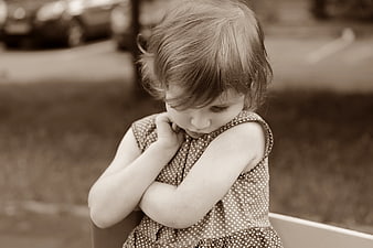 Sepia Portrait of Shy Little Girl Hiding Face in Polka Dot Dress