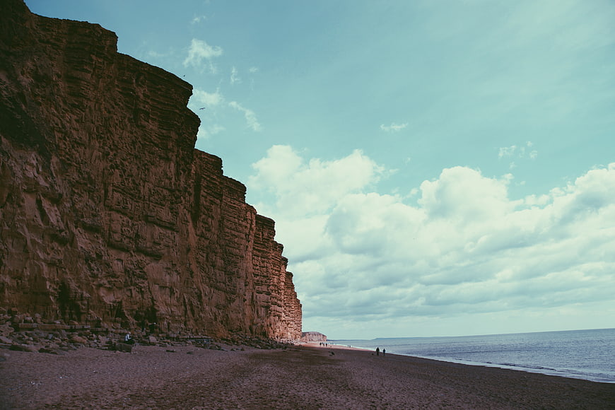 Dramatic Red Cliffs and Pebble Beach Coastal Landscape