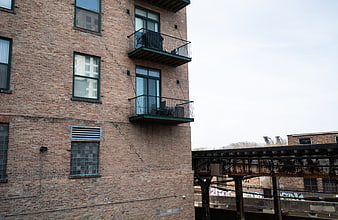 Urban Brick Building with Balconies and Train Tracks