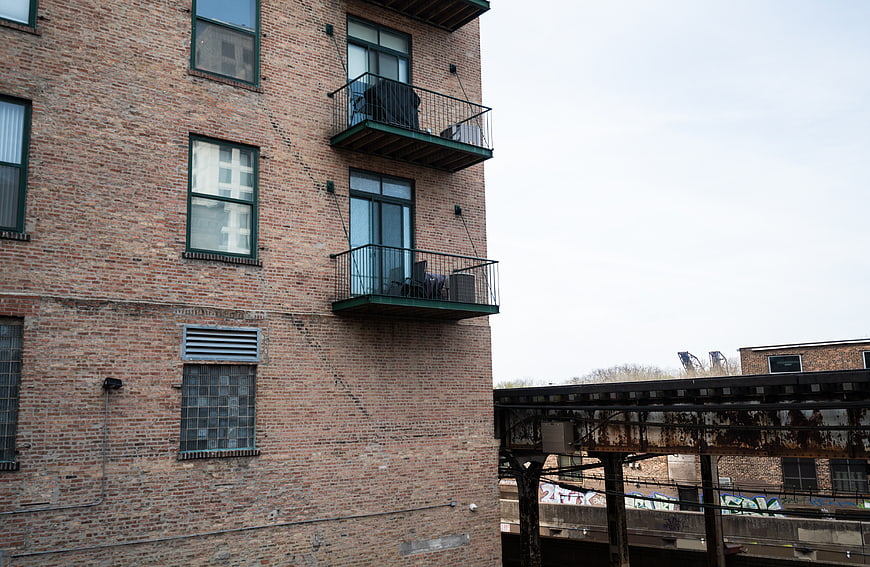 Urban Brick Building with Balconies and Train Tracks