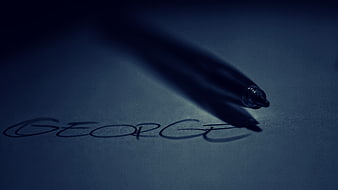 Dark moody pen writing name George on paper