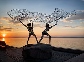 Metal Sculpture of Fishermen Casting Nets at Sunset