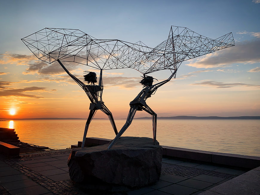 Metal Sculpture of Fishermen Casting Nets at Sunset