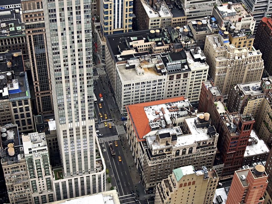 Aerial view of dense urban cityscape with skyscrapers and yellow taxis