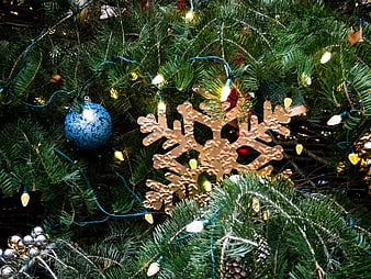 Gold Snowflake Ornament on Christmas Tree with Lights