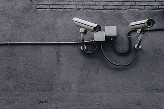 Two CCTV Security Cameras Mounted on Gray Concrete Wall