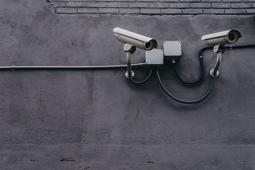 Two CCTV Security Cameras Mounted on Gray Concrete Wall