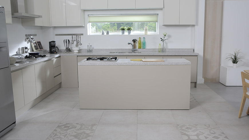 Modern white kitchen with central island and natural light