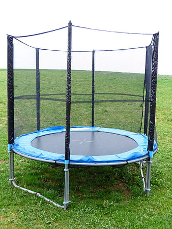 Blue Garden Trampoline With Safety Net On Green Grass