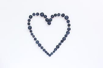 Blueberries arranged in a heart shape on white background