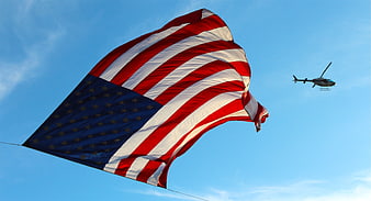 American Flag Flying with Helicopter in Blue Sky