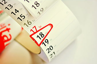Close-up of tear-off calendar with date circled in red
