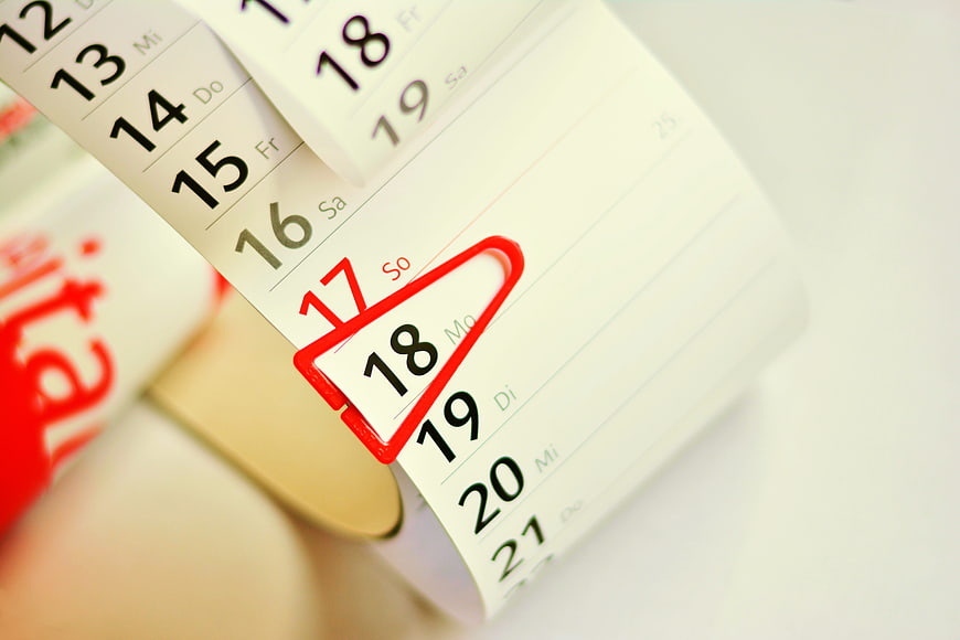 Close-up of tear-off calendar with date circled in red