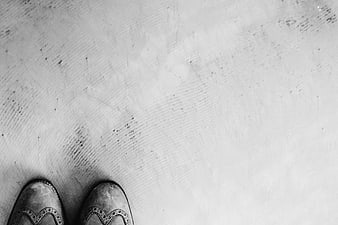 Black and white top view of brogue shoes on concrete