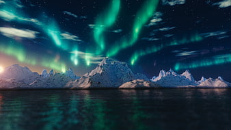 Vibrant Aurora Borealis Over Snowy Mountains and Water