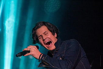 Male singer performing passionately on stage with microphone