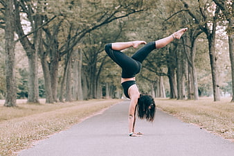 Woman Performing Handstand Yoga Pose on Forest Path