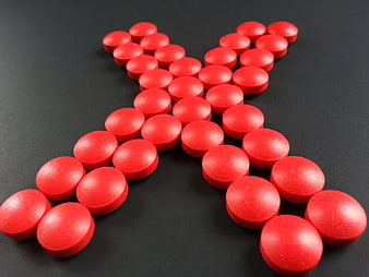Red Pills Arranged In X Shape On Dark Background